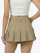 Person wearing a beige pleated skirt and white top on a white background
