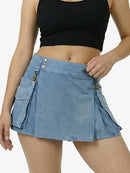 Person wearing a blue skirt with multiple pockets and a black top on a white background