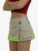 Person wearing a beige cargo skirt with reflective green stripes on a white background