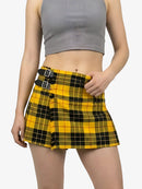 Person wearing a yellow plaid skirt with black straps on a white background