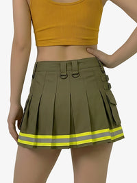 Person wearing a yellow crop top and green pleated skirt with reflective stripes on a white background