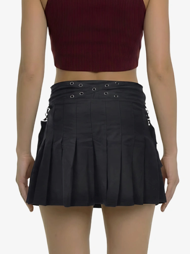 Black pleated skirt with eyelet details worn by a person on a white background