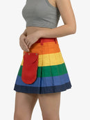 Person wearing a rainbow striped skirt with a red pocket on a white background