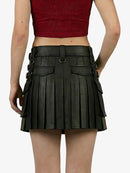 Black pleated leather skirt worn by a person on a white background