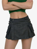 Person wearing a black denim skirt with button details on a white background
