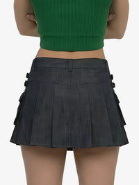 Person wearing a green top and black pleated skirt on a white background