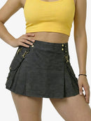 Person wearing a black skirt with gold buttons and a yellow top on a white background