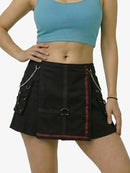 Person wearing a black skirt with chain details and a blue top on a white background