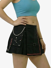 Person wearing a black skirt with chain details and a blue top on a white background