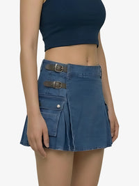 Blue denim skirt with metal buckles worn by a person on a white background