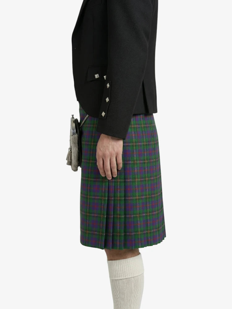 Person wearing a black jacket and green plaid kilt on a white background