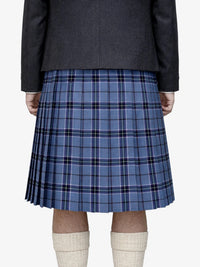 Person wearing a blue plaid kilt with a dark jacket on a white background