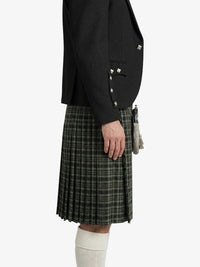 Person wearing a black blazer and plaid kilt on a white background