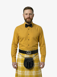 Man wearing a yellow shirt, bow tie, and kilt on a white background