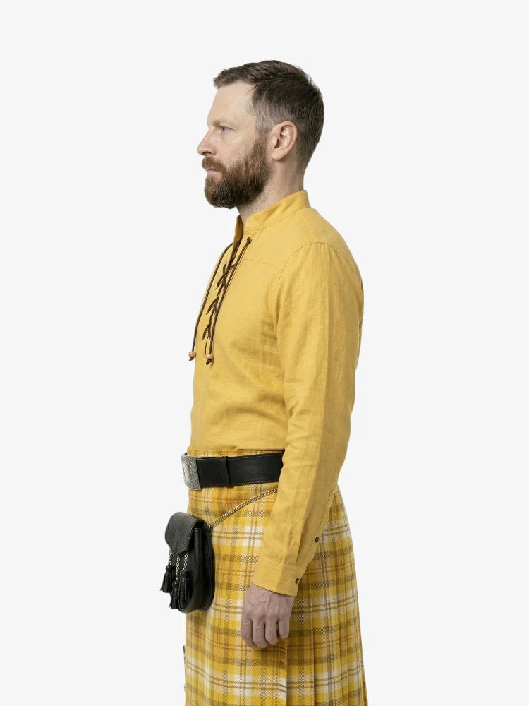 Man wearing a yellow shirt and plaid skirt with a black bag on a white background