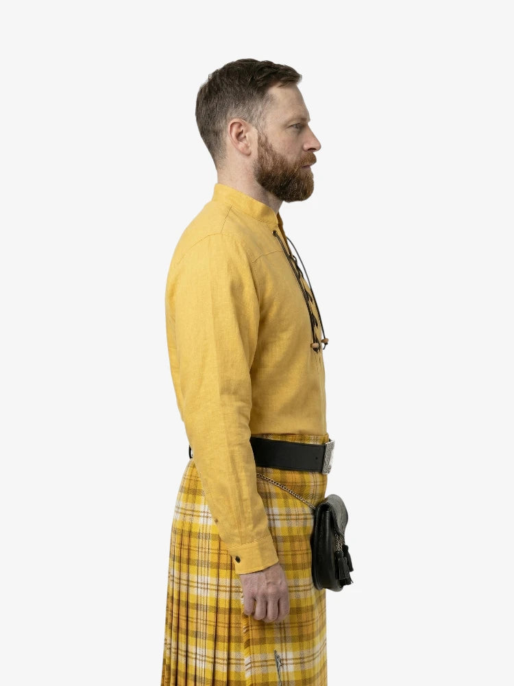 Man wearing a yellow outfit with a plaid skirt on a white background