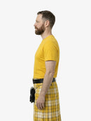 Man wearing a yellow shirt and plaid kilt on a white background