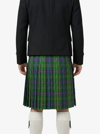 Person wearing a black jacket and green plaid kilt on a white background