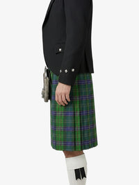 Person wearing a black jacket and green plaid kilt on a white background
