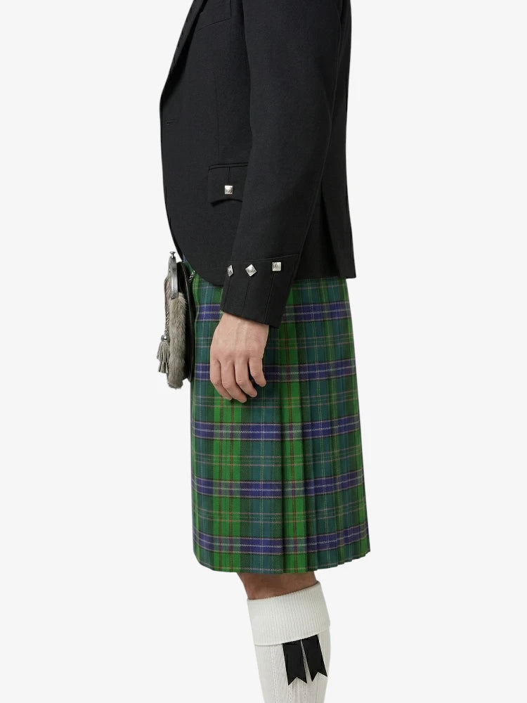 Person wearing a black jacket and green plaid kilt on a white background