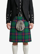 Person wearing a traditional Scottish kilt with a tartan pattern on a white background