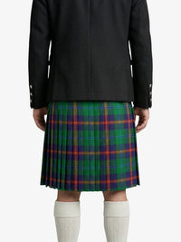 Person wearing a black jacket and green plaid kilt on a white background
