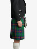 Person wearing a black jacket and green plaid kilt on a white background